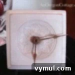 A charming DIY wood table clock with painted hands and stand.