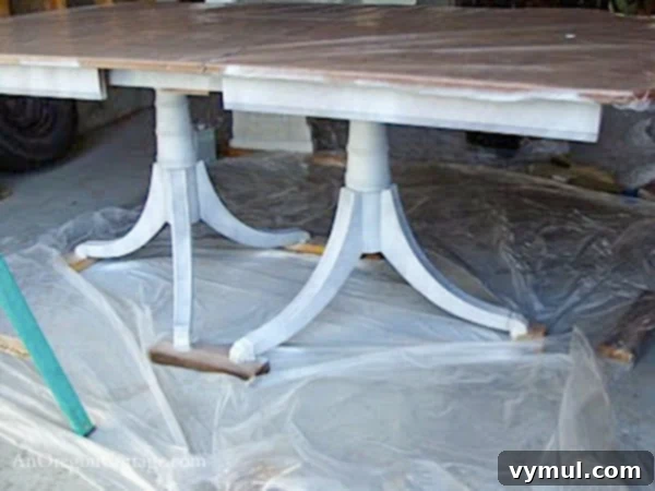 primed dining table base-step2: The base of a dining table covered in a uniform layer of primer, ready for the final coat of paint.