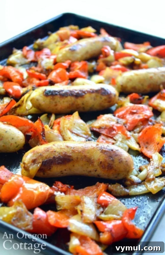 Sheet Pan Sausage & Veggies 2 Vibrant roasted sausages with colorful peppers and onions on a sheet pan, ready to serve