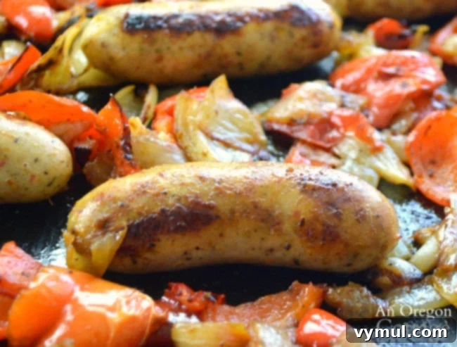 Sheet Pan Sausage & Veggies 7 Close-up of perfectly roasted Italian sausages, caramelized onions, and tender bell peppers on a baking sheet
