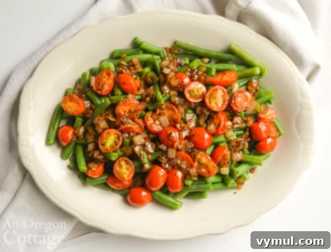Speedy Healthy Green Bean Delight with Caramelized Onions and Tomatoes 5 Overhead shot of green beans topped with caramelized onions and tomatoes on a serving platter.