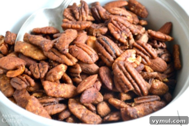 Sweet & Spicy Sriracha Nuts 5 Sriracha-Honey Nut Mix served in a rustic bowl, showcasing its golden brown, spicy coating