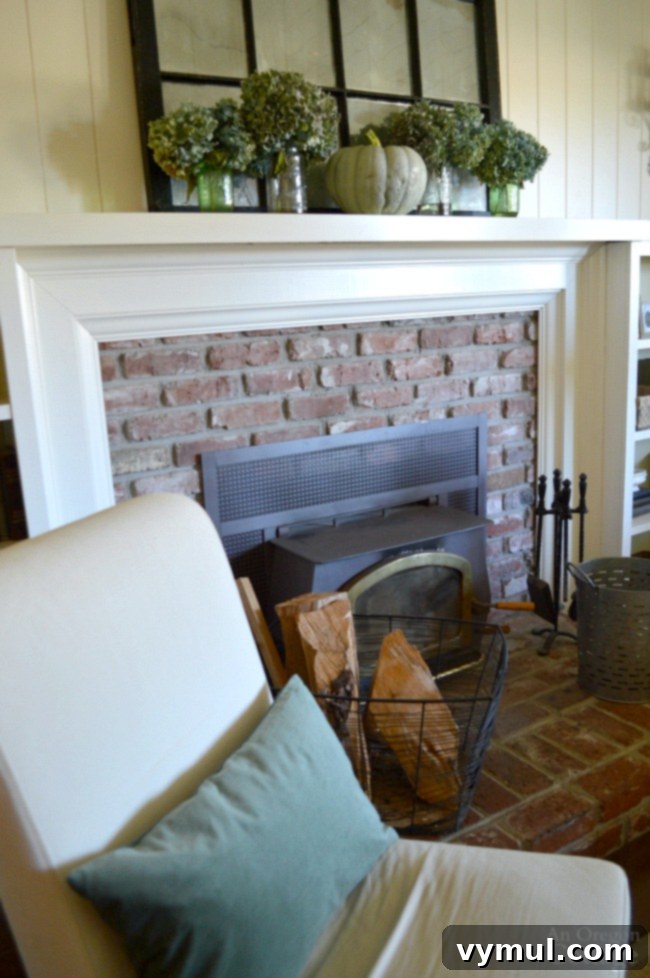 Autumnal Simplicity in Green and White 6 A welcoming Simple Fall Decor arrangement showcasing a fireplace mantel adorned with dried hydrangeas and white pumpkins, creating a serene and inviting atmosphere.