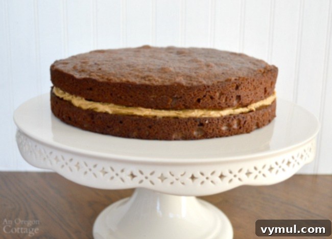 Spreading a rich layer of peanut butter frosting onto the first chocolate cake layer for the celebration cake.