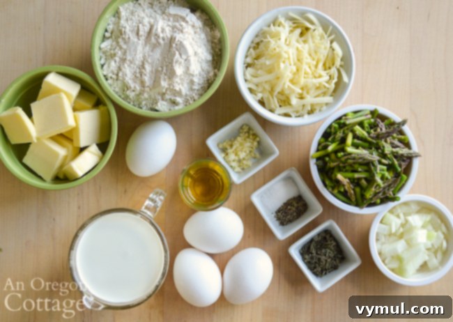 Ingredients for a spring asparagus quiche displayed on a white surface.
