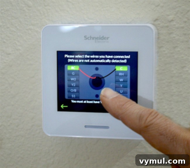 Attaching the front display unit of the Wi-Fi smart thermostat to the securely mounted backplate and powering it on