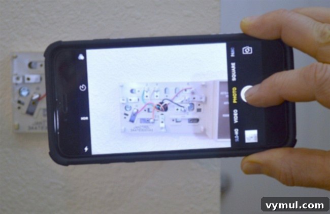 Taking a crucial photograph of the old thermostat's existing wiring configuration before any disconnections