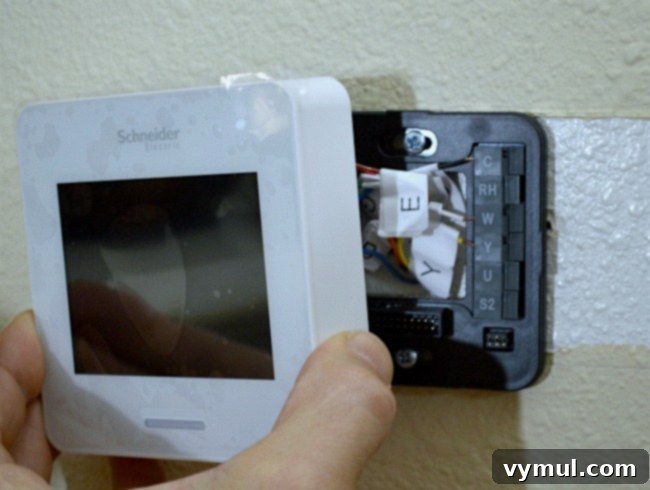 Connecting individually labeled wires to their corresponding terminals on the new Wi-Fi smart thermostat backplate
