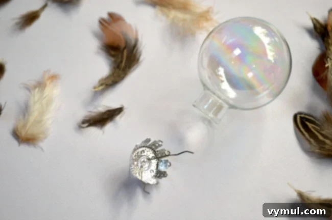Effortless Feather & Glass Christmas Ornament Craft 5 Preparing glass ball for feather and glass Christmas Ornament DIY by removing the metal top.