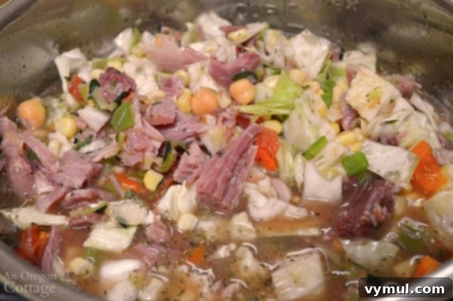 Easy Ham Bone Soup with Beans and Vegetables: Crockpot, Instant Pot, or Stovetop 4 A close-up of a pot on the stove, with ham broth simmering and various fresh vegetables being added to create a delicious Harvest Vegetable Ham Bone Soup.