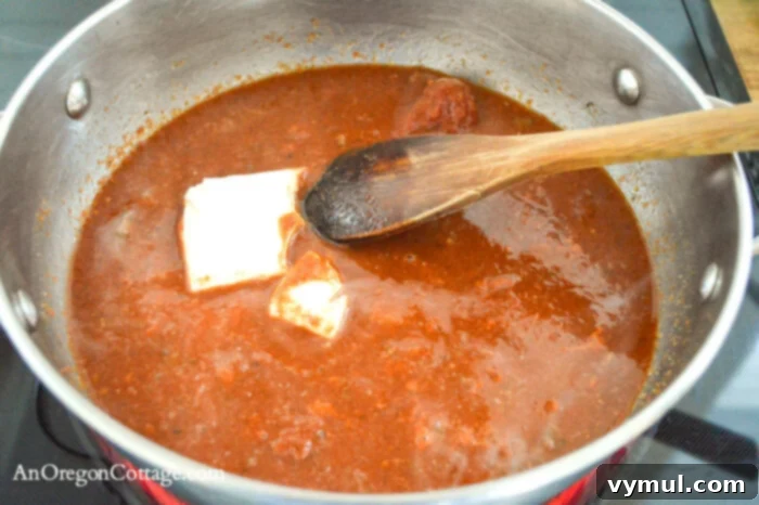 Adding cream cheese to the warm baked pasta sauce