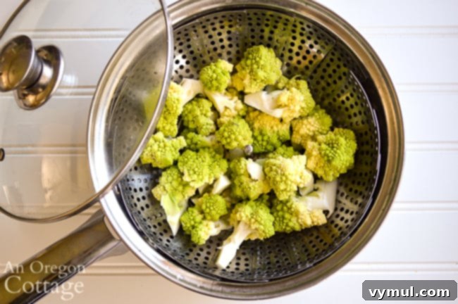Velvety Broccoli Cauliflower Parmesan Bake 4 Steaming vibrant Romanesco broccoli and cauliflower florets in a pot