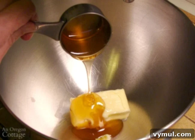 Pillowy Soft 100% Whole Wheat Dinner Rolls 3 Softened butter and honey being mixed in a stand mixer bowl.