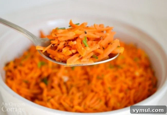 Tangy Lemon Garlic Baked Grated Carrots 4 A serving spoon scoops out a portion of warm, garlicky baked grated carrots from a baking dish.