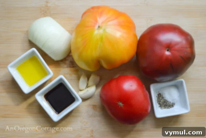 fresh tomato bruschetta ingredients laid out: tomatoes, onion, garlic, olive oil, balsamic vinegar