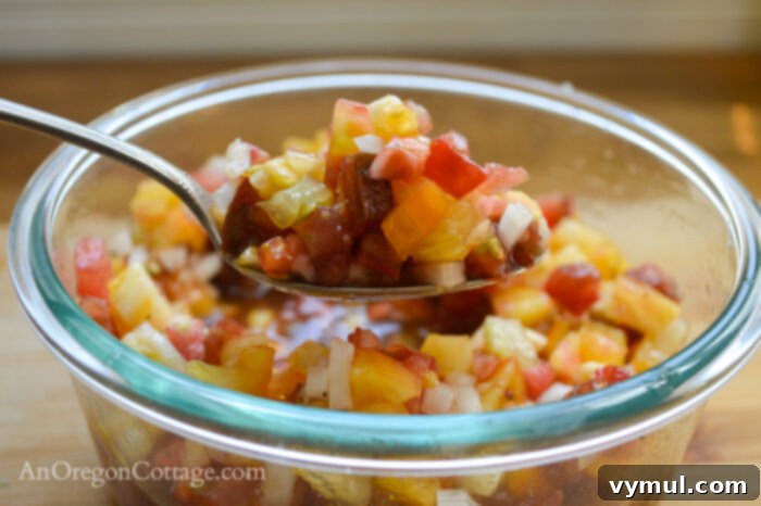 a spoonful of fresh tomato bruschetta topping, showing diced tomatoes and onions