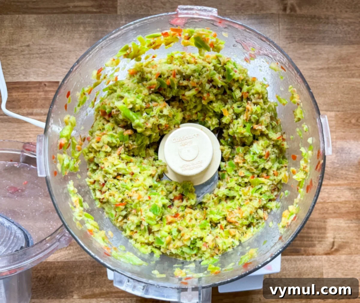 Chopped peppers in a food processor, demonstrating the quick and efficient preparation for homemade salsa.