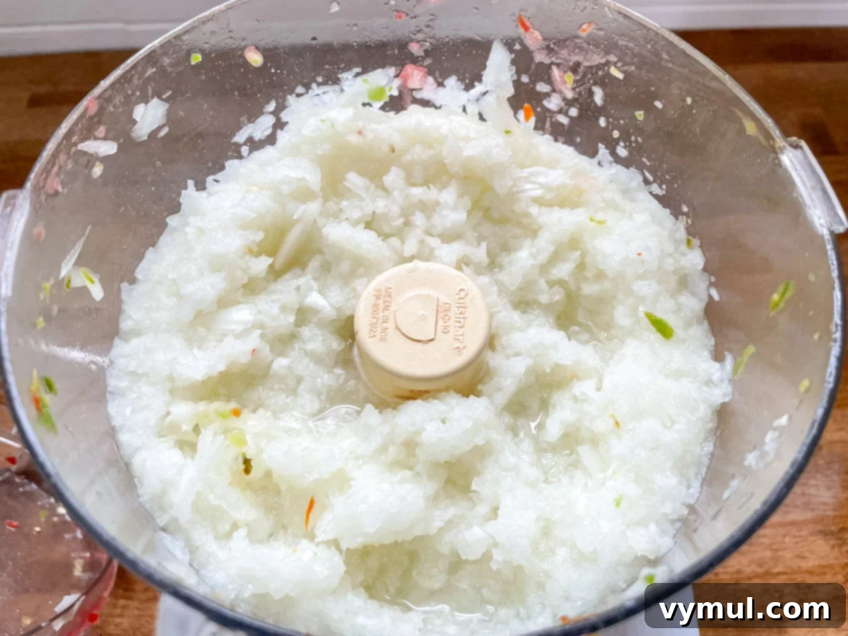 Onions finely chopped in a food processor, ready to be added to the homemade salsa mixture.