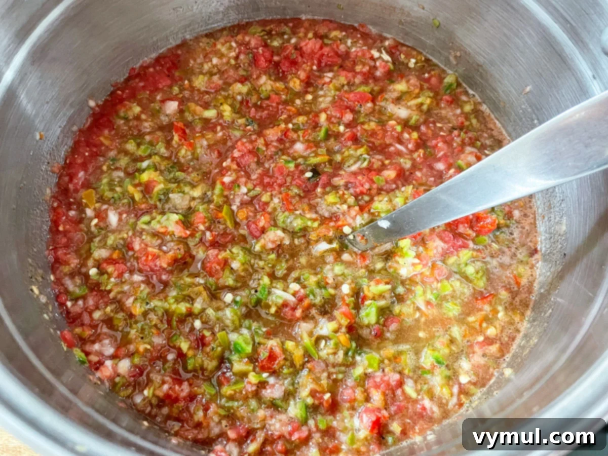 All fresh salsa ingredients, including chopped tomatoes, peppers, onions, and garlic, combined in a large stockpot.