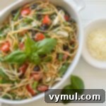 Close-up of the delicious summer pasta salad, garnished with basil and parmesan