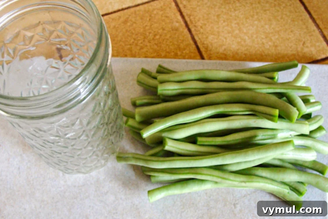 pile of cut green beans next to canning jar
