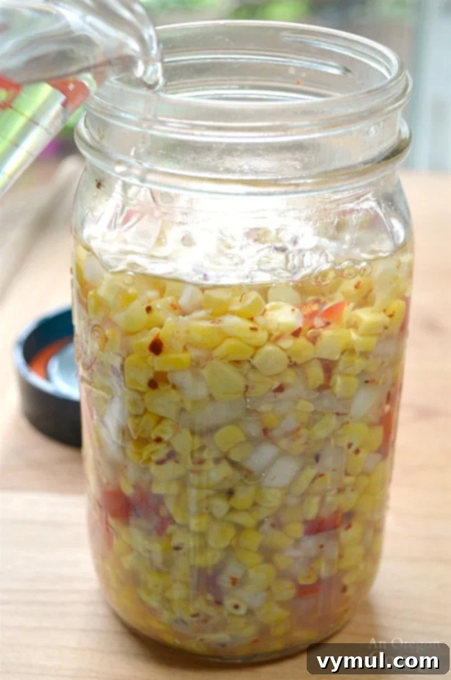 Easy 5-Minute Fermented Corn Relish Magic 7 Adding water to Easy Fermented Corn Relish in a jar