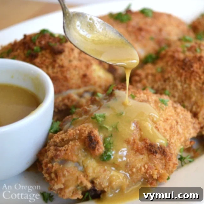 Baked Maple Mustard Chicken being drizzled with sauce