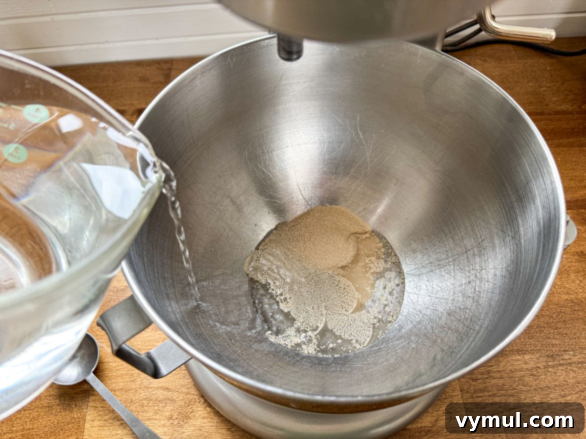 Foolproof Dutch Oven Whole Wheat Artisan Bread 7 Step 1: Water, yeast, and salt being mixed in a bowl for artisan bread.