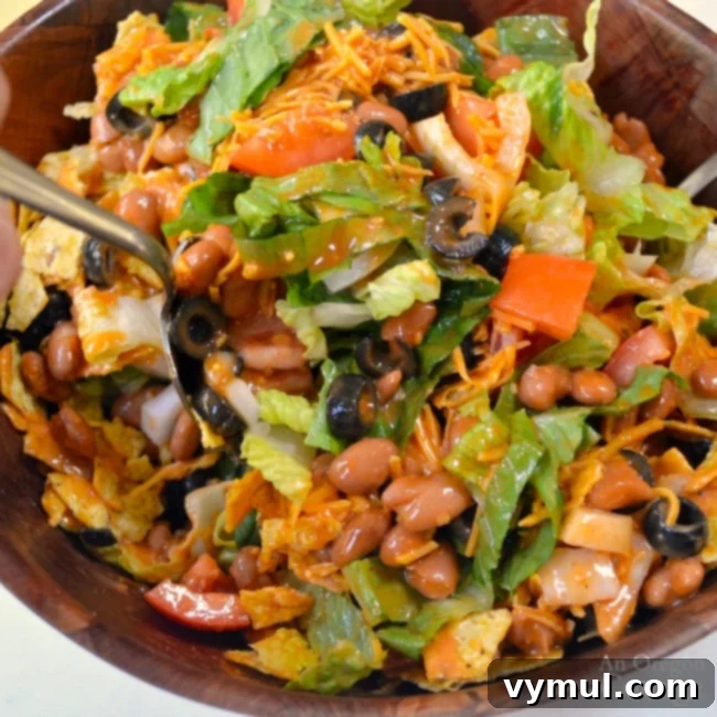 Mixing Tex-Mex Salad with ranch style beans and dressing