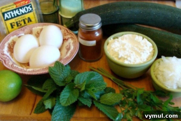 Zesty Zucchini Feta Fritters 4 All fresh ingredients for zucchini feta fritters laid out on a wooden board: zucchini, onion, feta cheese, mint, parsley, garlic, paprika, black pepper, red pepper flakes, flour, eggs, and limes.