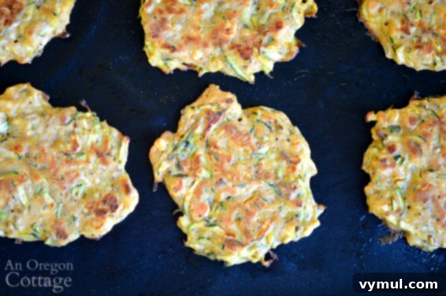 Zesty Zucchini Feta Fritters 7 Close-up of golden-brown baked zucchini feta fritters, showcasing their crisp texture and appetizing appearance, ready for serving.