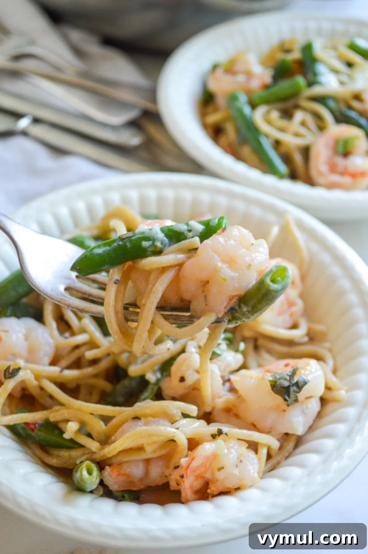 Easy 30 Minute Creamy Shrimp Pasta with Green Beans 2 eating shrimp pasta from white bowl