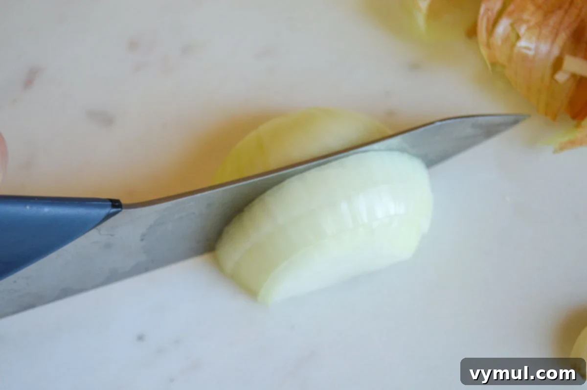 Easy 30 Minute Creamy Shrimp Pasta with Green Beans 5 slicing half of onion