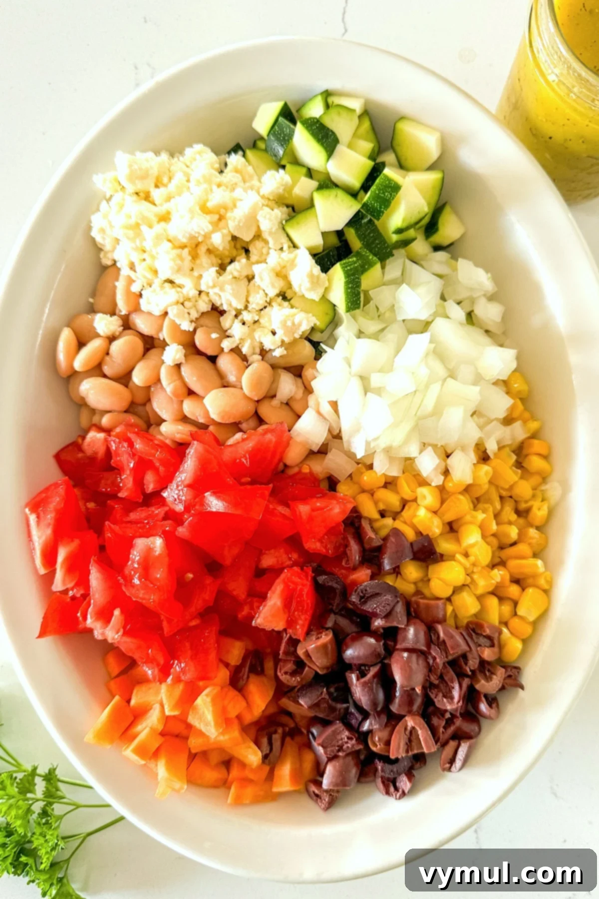 Fast Flexible Chopped Salad 4 A large white bowl being filled with various chopped salad ingredients