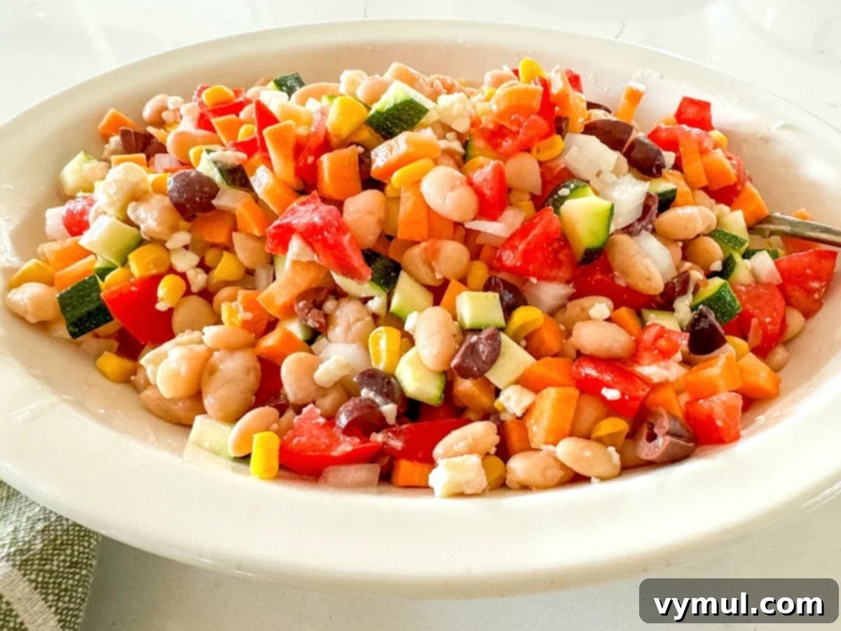 Fast Flexible Chopped Salad 5 Hands mixing chopped salad ingredients in a white bowl with a spoon