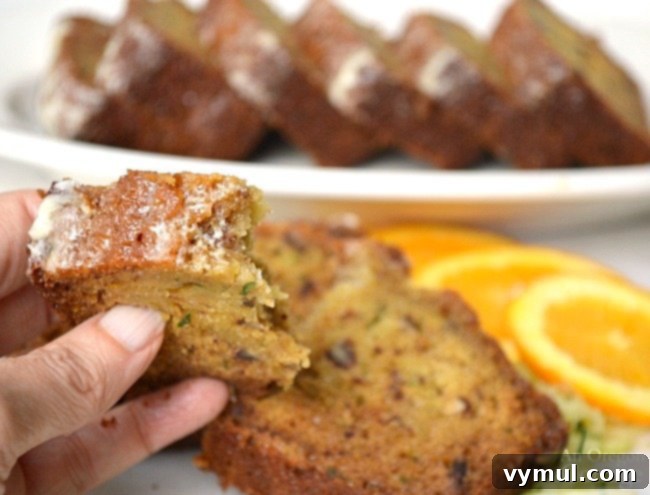 Slice of orange zucchini bread with a bite taken out, showing moist texture