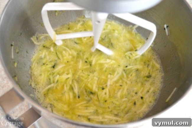 Close-up of ingredients being mixed in a bowl for orange zucchini bread