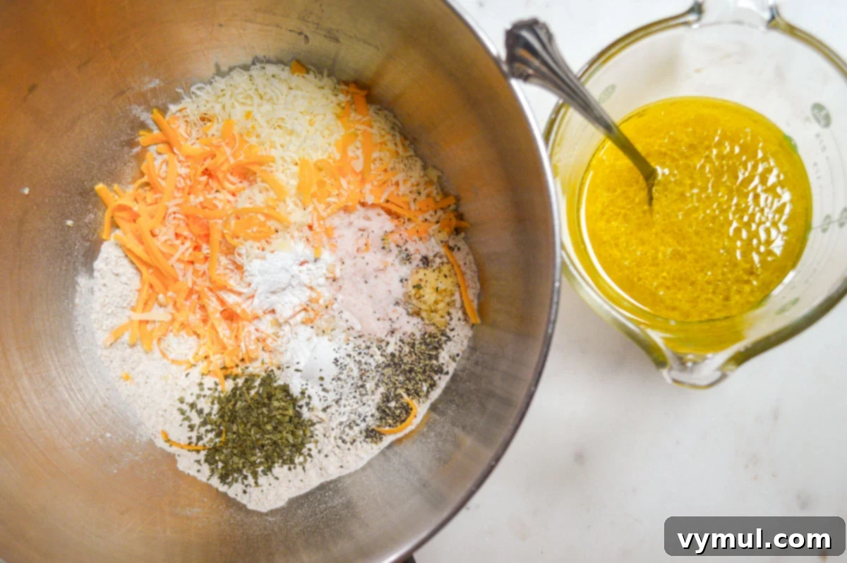 Wet and dry ingredients for zucchini bread before mixing, showing flour, cheese, spices, and grated zucchini in one bowl, and eggs, oil, and buttermilk in a measuring cup.