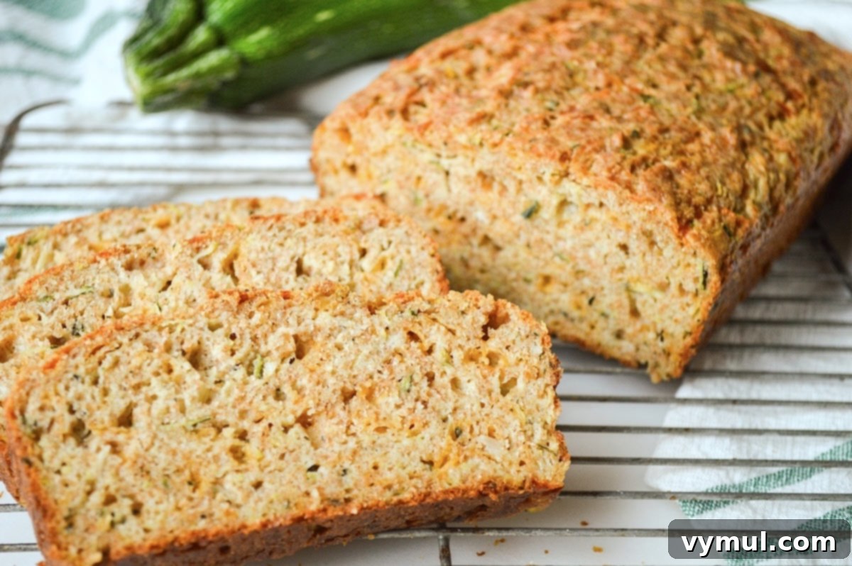 Slices of savory zucchini bread baked in a 9x5-inch pan, showing a slightly flatter, wider profile.