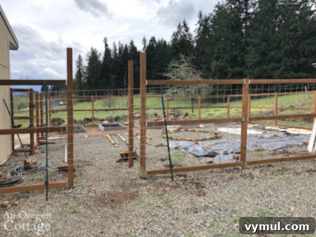 Vegetable garden with new fence posts and beds, showcasing farmhouse renovation progress