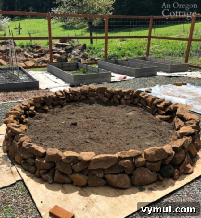 Rustic round raised bed construction with layered soil, manure, straw, and compost for organic gardening