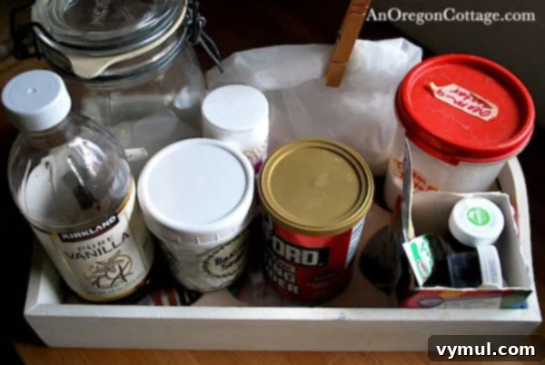 Close-up of a wooden tray holding various baking ingredients and food coloring tubes
