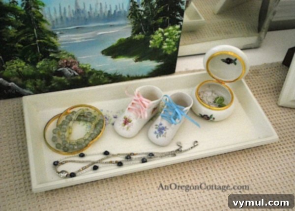 Wooden tray with jewelry and sentimental baby booties on a bedroom dresser