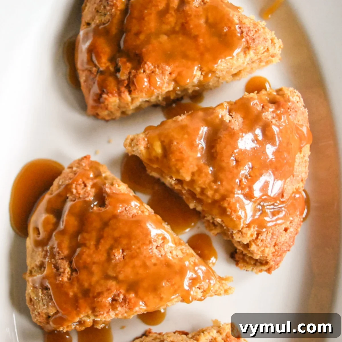 Luscious Double Apple Scones with Golden Caramel Glaze 3 Finished apple scones with a delicate caramel glaze displayed beautifully on a white plate, ready to be served.