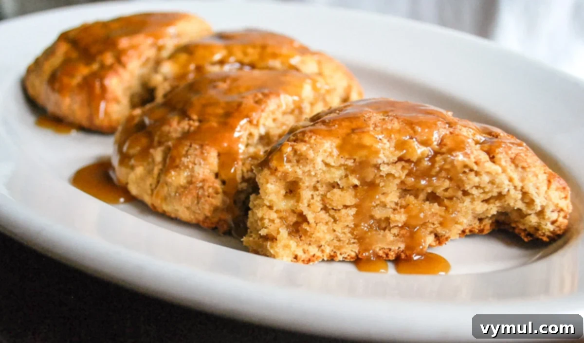 Luscious Double Apple Scones with Golden Caramel Glaze 8 Close-up of baked apple scones with caramel glaze beautifully dripping down their sides, showcasing their moistness.