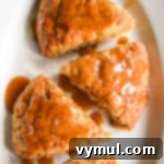 Luscious Double Apple Scones with Golden Caramel Glaze 9 Finished apple scones with a delicate caramel glaze displayed beautifully on a white plate, ready to be served.