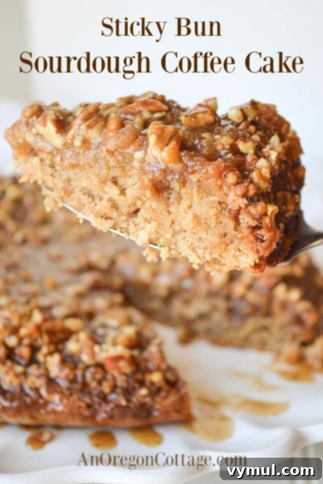 A generous slice of moist sticky bun sourdough coffee cake with rich caramel and pecans, ready to be enjoyed.