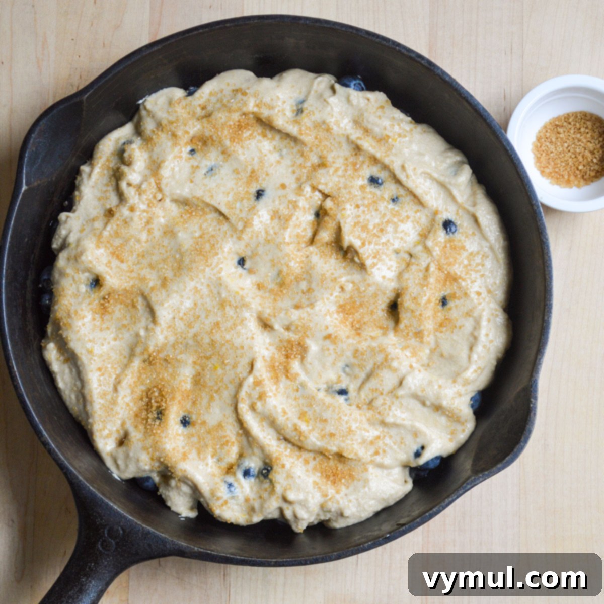 batter spread over blueberries in skillet