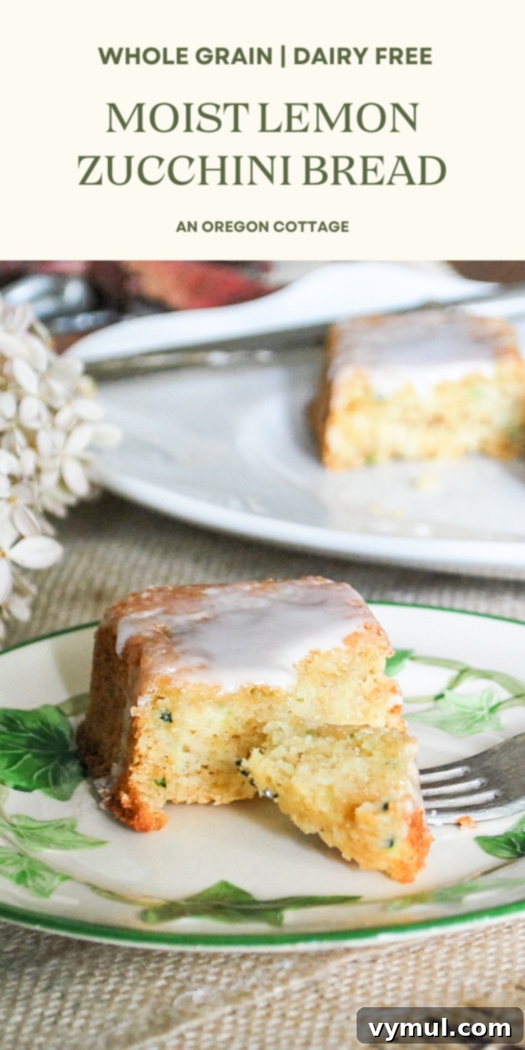 Two loaves of zucchini lemon bread, one whole and one sliced, on a wooden board, with fresh lemons and zucchini. Ideal for Pinterest sharing.