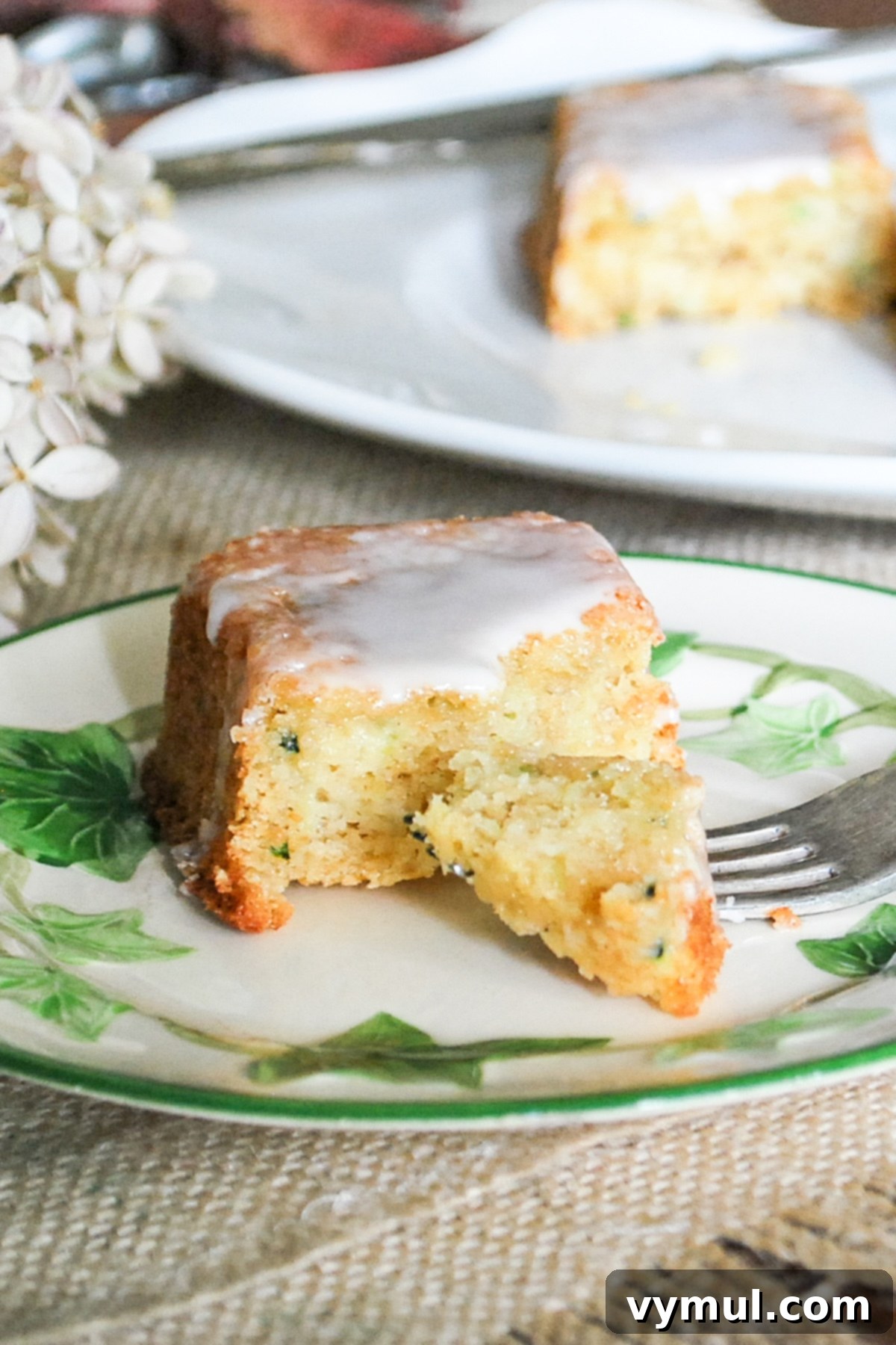 A hand reaching for a slice of moist lemon zucchini bread on a cutting board, highlighting its delicious appearance and inviting texture.